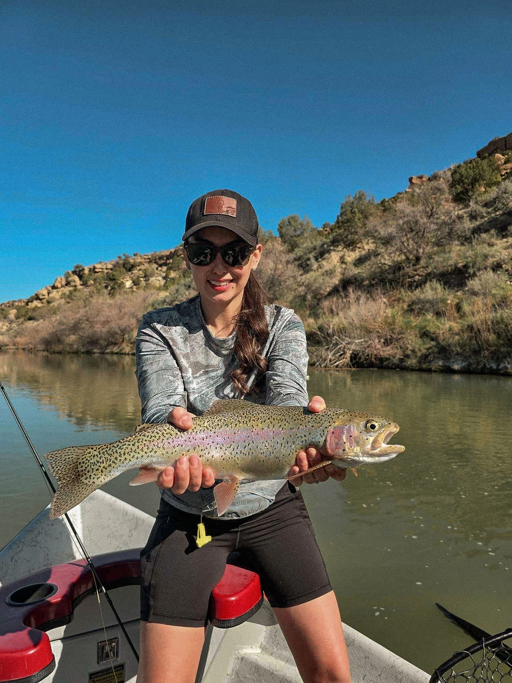 Smiling guide angler holding a massive trophy brown trout.